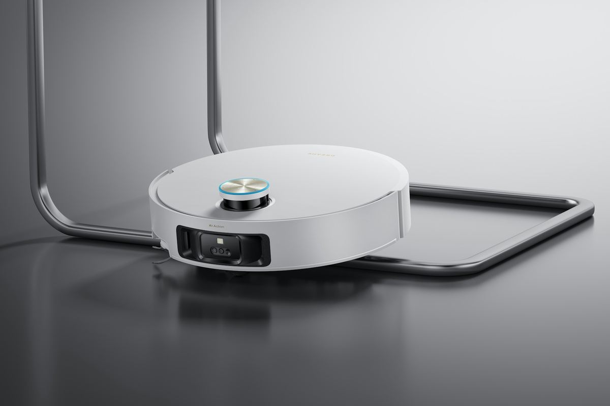 A white robot vacuum with a lidar turret next to a black metal chair leg